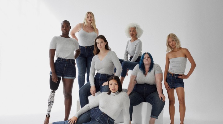 A group of diverse women from different backgrounds wearing white t-shirts and jeans.