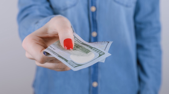 Woman holding 100 USD note