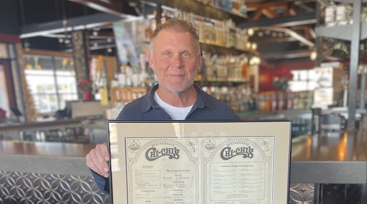 Image of Chi Chi's founder holding the restaurant's menu.