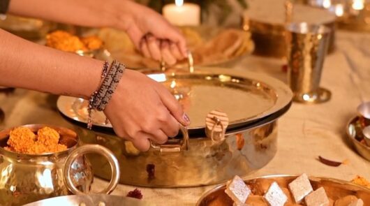 A woman holding a pot from India cookware brand P-Tal.