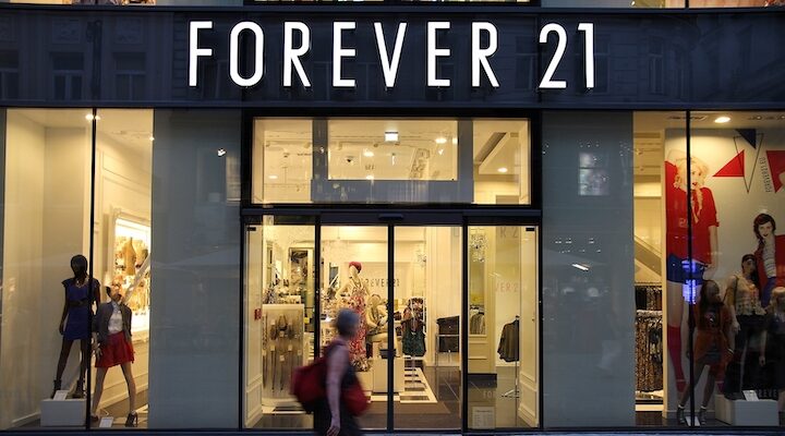 A woman walking in front of a Forever 21 store front in Vienna, Austria.