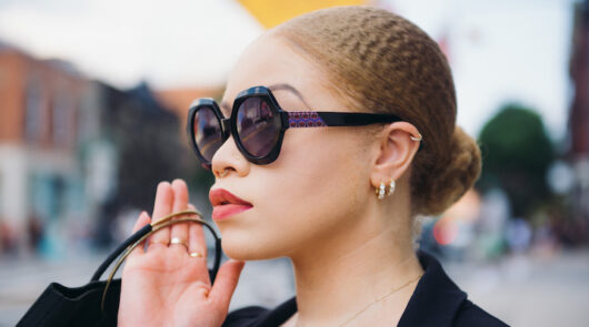 An image of a young woman wearing a pair of frames from Vontélle Eyewear looking off to the side.