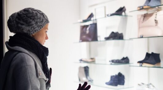 a woman window shops in front of a fashion store