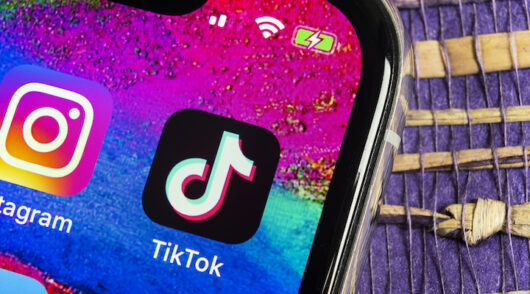 A close-up of an iPhone screen showcasing the TikTok logo.