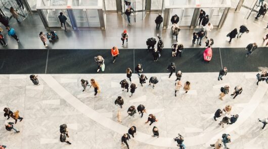 People crowd walking in shopping mall entrance