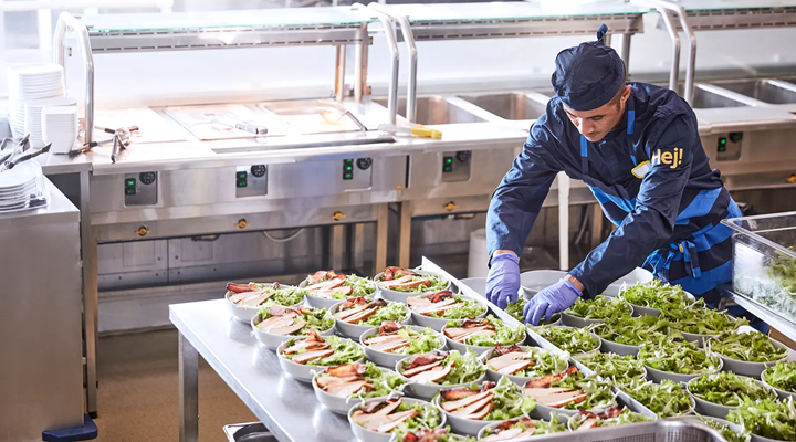 a man assembling bowls of salad in an ikea kitchen