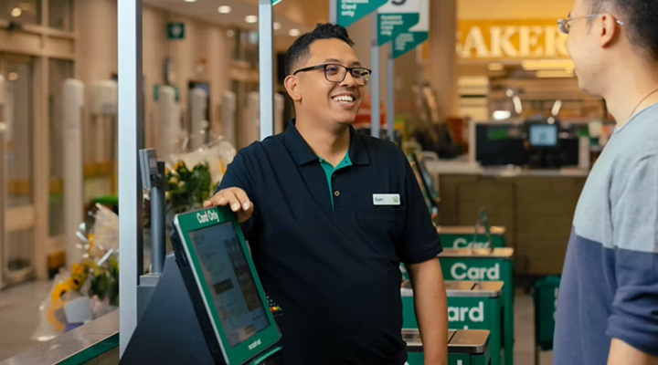 A man standing by a self-checkout in a Woolworths supermarket