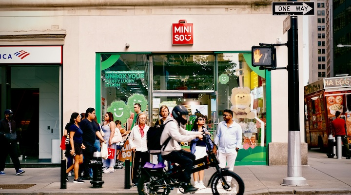 People standing outside a Miniso retail store in New York City.