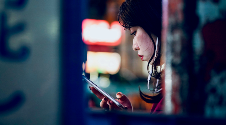 a woman checking her smartphone on a city street