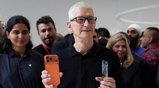 Apple CEO Tim Cook holds an iPhone 17 pro and an iPhone air