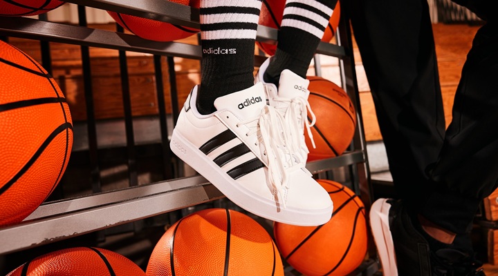 Image of sneakers in front of basketballs.