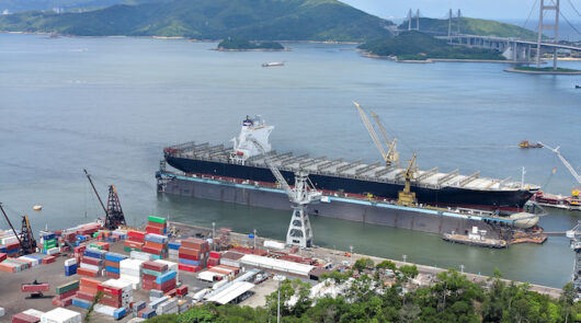 A container ship in a terminal harbour loaded with shipping containers.