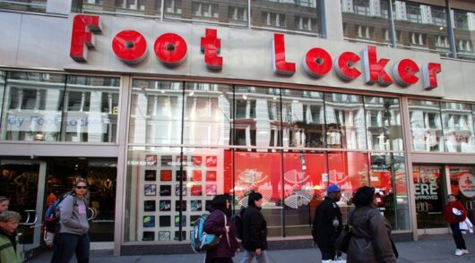 people walk in front of Foot Locker store