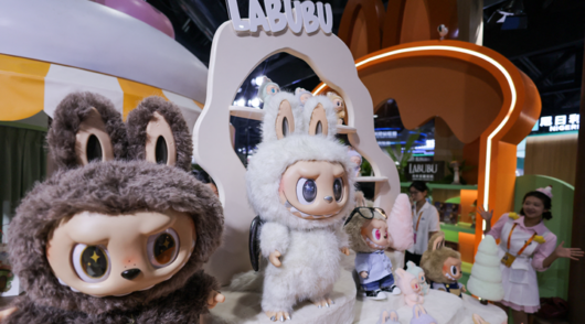An employee gestures next to Labubu toys on display at Pop Mart’s booth at China International Fair for Trade in Services (CIFTIS) in Beijing, China