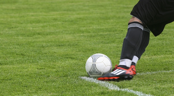 a person's foot is kicking a ball