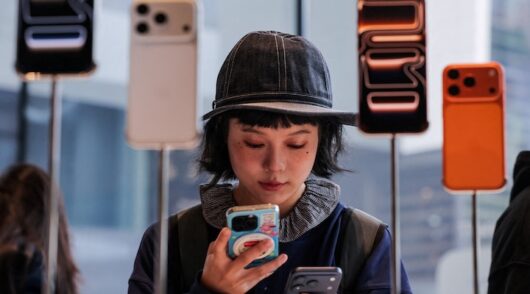 A woman uses her smartphone inside the Apple store