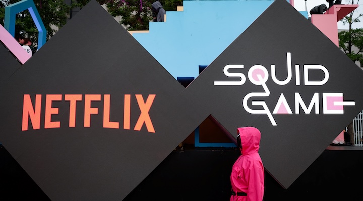 A performer dressed as a 'Squid Game' soldier in front of the Netflix and Squid Game logos
