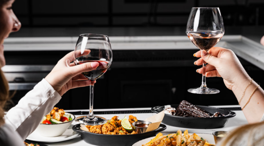 Customers hold wine glasses at Bar Louie