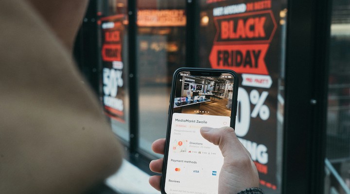 A man holding a phone with the screen showcasing virtual Black Friday deals.