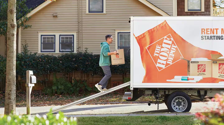 man carries box to a Home Depot truck