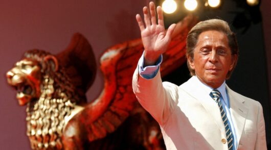 talian fashion designer Valentino Garavani waves as he arrives for the premiere of the movie "Valentino: The Last Emperor"