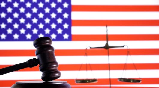 The US flag, a judge gavel and a vintage scale are seen in this illustration