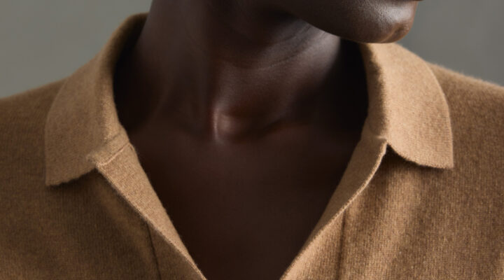 A male model wearing a camel brown Quince cashmere shirt.