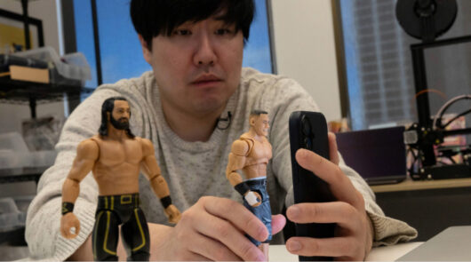 Man scanning action figures by phone.