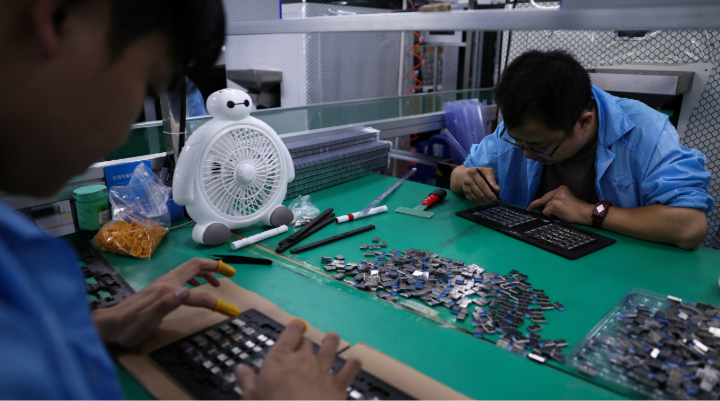 Workers assembling electronics components.