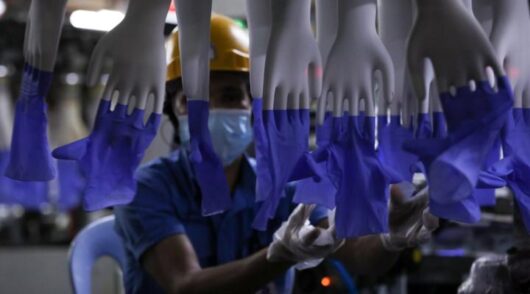 Worker handling rubber gloves.