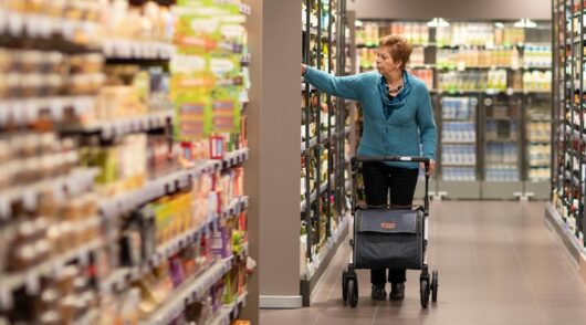 Pensioner shops in supermarket aisle