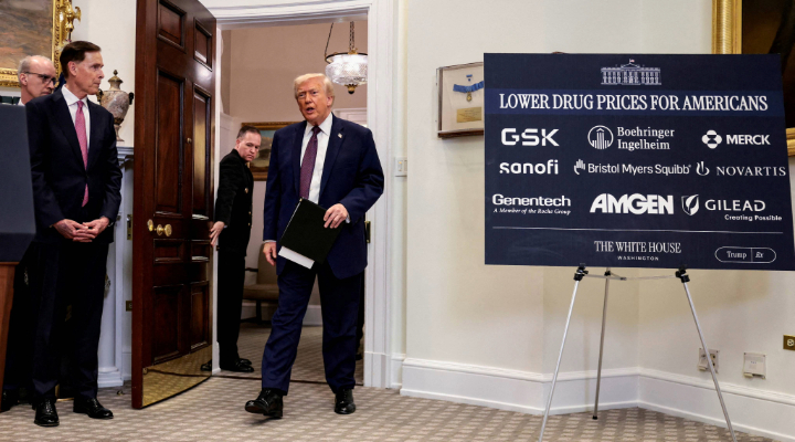 Trump enters room with drug pricing sign.