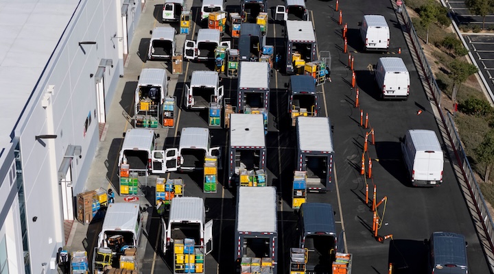 Workers load vans with packages at an Amazon fulfillment center in Valencia, California