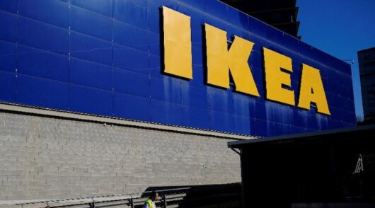 A worker walks past a logo of IKEA on the facade of an Ikea store in Barcelona