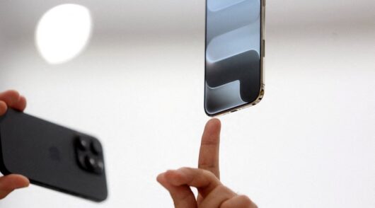 A person points to an iPhone during Apple's event at the Steve Jobs Theater on its campus in Cupertino