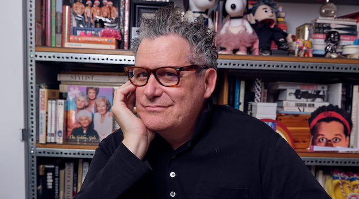 Target’s creative director Isaac Mizrahi posing in front of a bookshelf.
