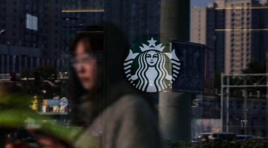 A Starbucks coffee house is pictured through glass of a building in Beijing