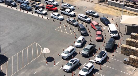 Cars queue at food assistance site.