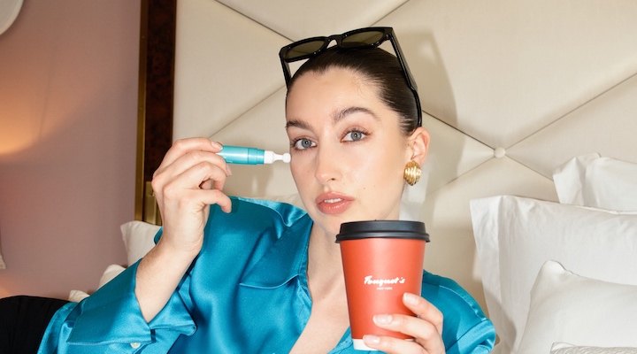 Today-Tomorrow Beauty founder Indianna Roehrich lying on a bed in teal pajamas.