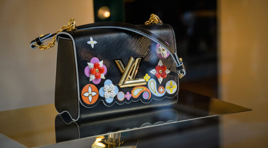 A black Louis Vuitton handbag with colorful embellishments.