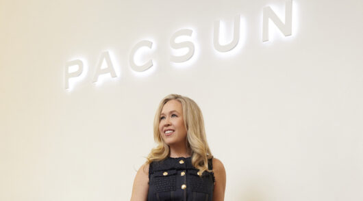 Pacsun CEO Brieane Olson standing in front of a beige wall.