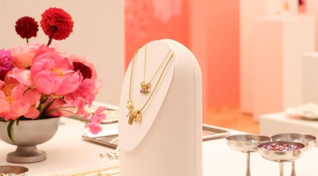 A pink display showcasing Pandora jewelry pieces.