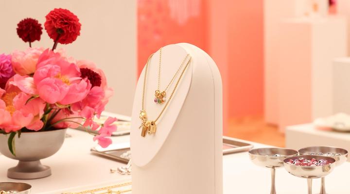 A pink display showcasing Pandora jewelry pieces.