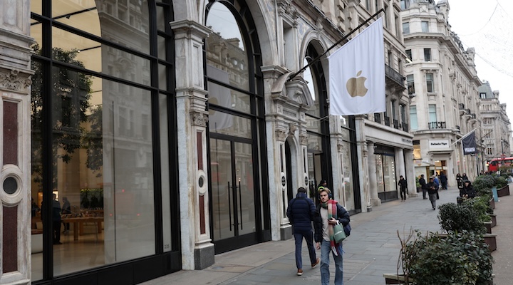 People walk past an Apple store in London