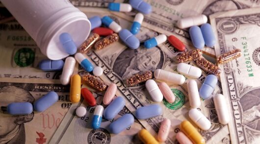 US dollar banknotes and medicines are seen in this illustration taken