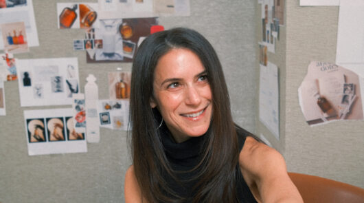 A headshot of Dana Steinfeld in front of a creative moodboard.