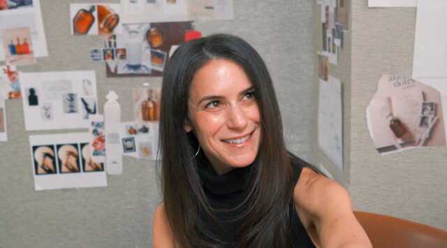 A headshot of Dana Steinfeld in front of a creative moodboard.
