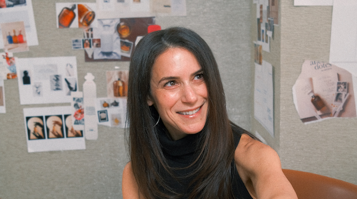 A headshot of Dana Steinfeld in front of a creative moodboard.