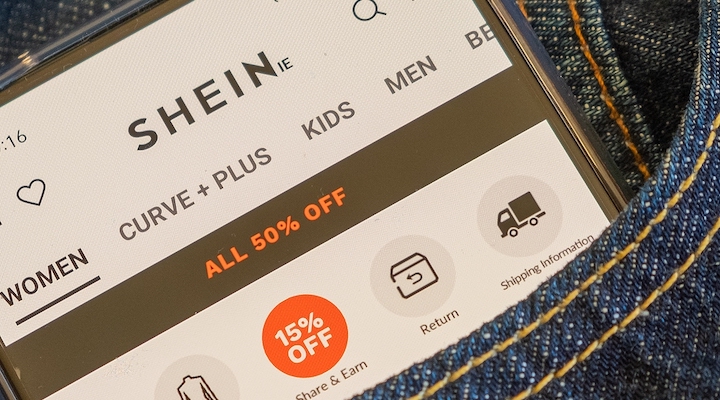 A smartphone in a jean pocket with the Shein website on display.