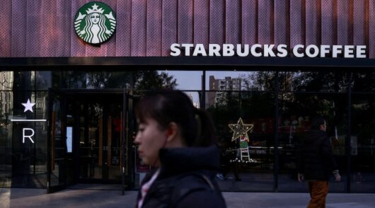 People walk past a Starbucks coffee shop in Beijing